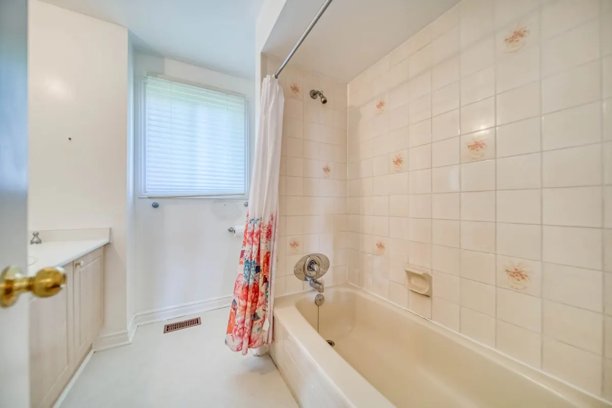 The bathroom before: a beige tub with floral tile.